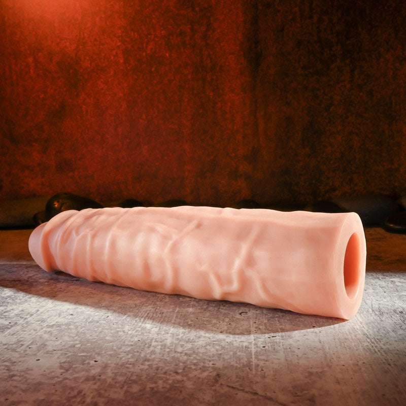 Adams 3 Realistic Extension - Flesh-toned TPR rubber enhancer with textured surface and hollow interior on textured background