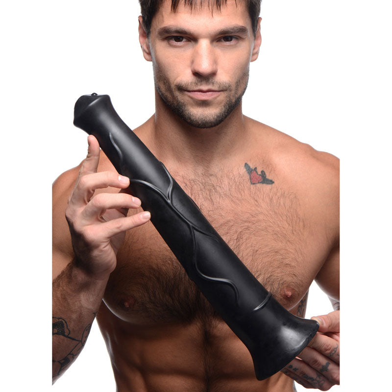 Man holding the long black Pony Boy horse dildo across his chest to show its length and veined shaft