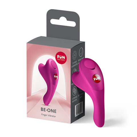 Magenta Fun Factory BE-ONE finger vibrator stands beside its grey and pink retail packaging.