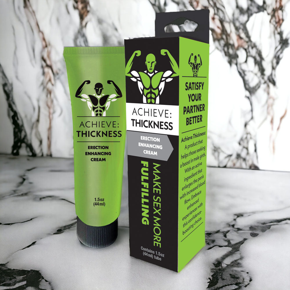 Achieve Thickness enhancement cream tube and retail box with muscular figure logo on marble background