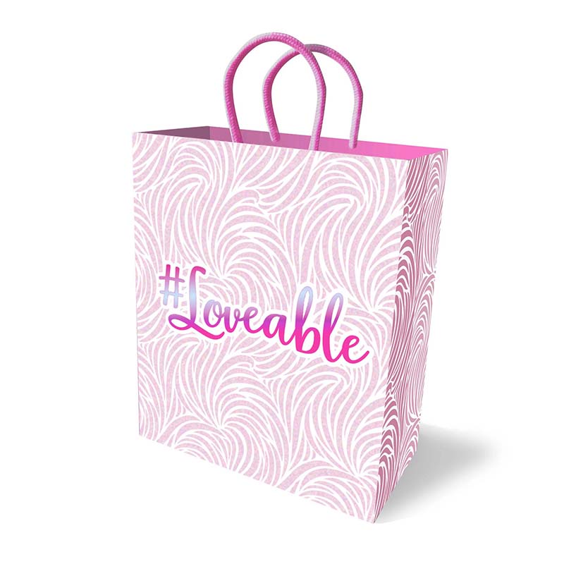 Loveable gift bag in pale pink with swirl pattern and pink handles, featuring metallic text on white background