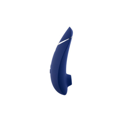 A blueberry Womanizer Premium 2 clitoral stimulator with silver accents appears next to its matching box, displaying the Womanizer brand, product name, tagline "Define your luxury," and highlighting advanced Pleasure Air Technology.